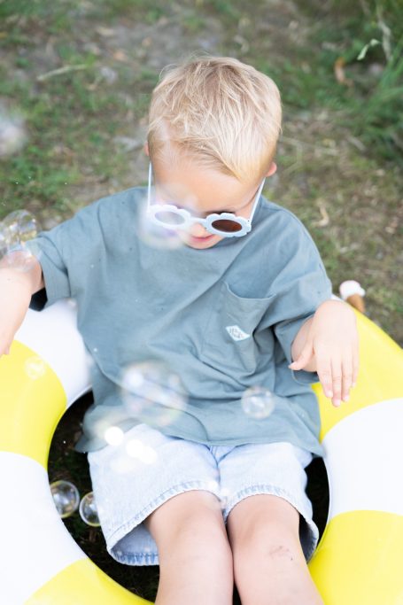 Kind mit Sonnenbrille im Schwimmring – entspannter Kita-Fototag im Allgäu