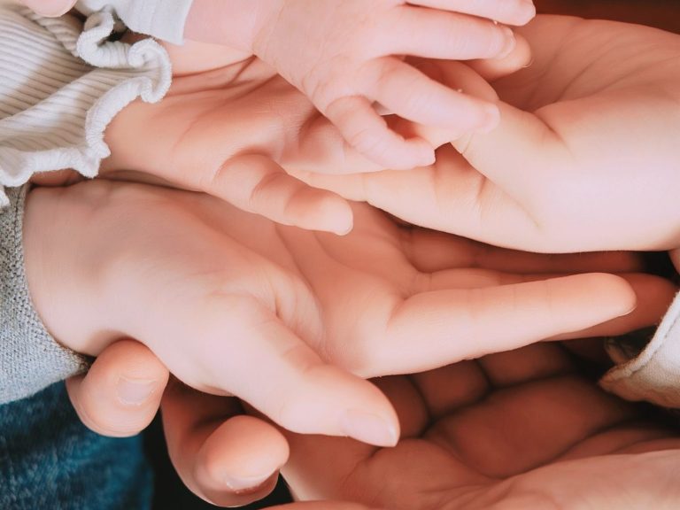 Familie mit Neugeborenem kuschelt zuhause auf dem Sofa – Familienfotografie im Unterallgäu
